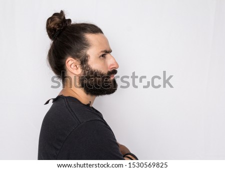 Portrait profile of hipster beard man looking away with thoughtful expression. Standing against white background.