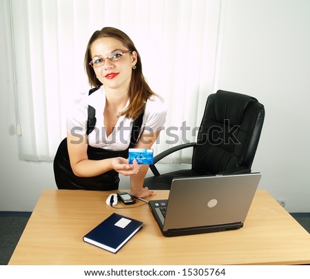 beautiful woman showing credit card in office
