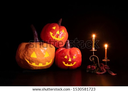 pumpkin from paper mache with glowing light and Candlestick on black background