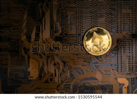 Ethereum coin on circuit board with soft focus at coin, financial concept.