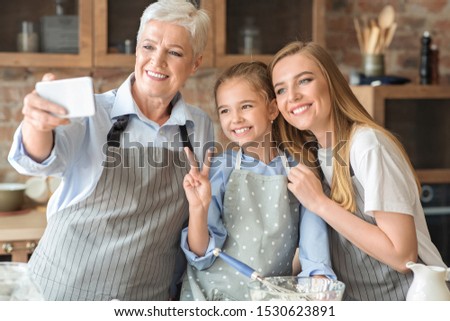 Friendly female family making selfie using smartphone at kitchen, cropped