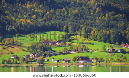 Beautiful autumn scene of Wolfgangsee lake. Colorful morning view of Austrian Alps, Europe. Beauty of nature concept countryside landscape background. Alpine village houses in fall forest by the lake