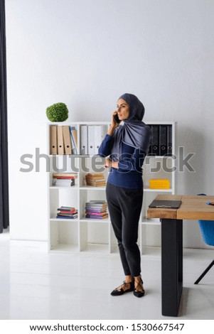 Muslim woman talking on the phone. Thoughtful look and negotiation skills. Portrait of a self-made female entrepreneur.