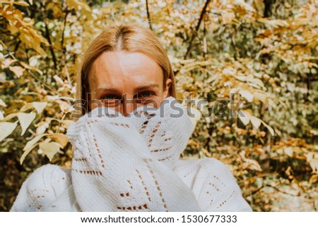 Blonde woman with smiling blue eyes cover her mouth