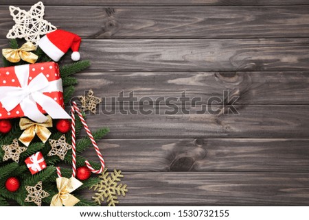 Christmas tree branches with toys and gift box on wooden table
