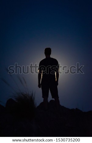 Guy's silhouette against the Moon