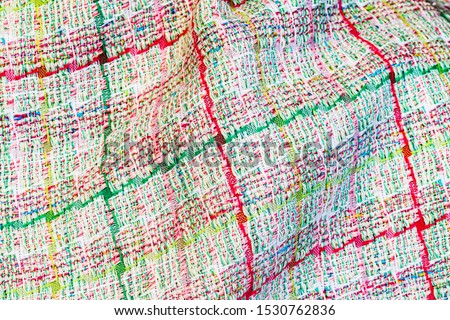 Abstract multicolor cloth texture, close up fashion background. Multicolored plaid tweed fabric. Fashionable green clothes background, copy space, text place