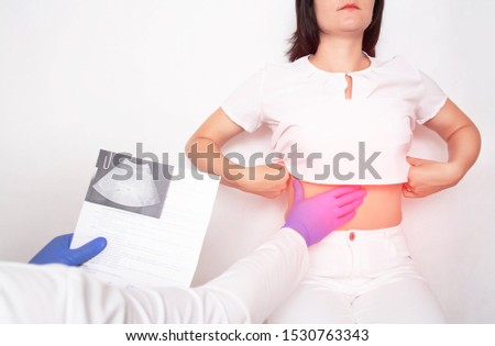The doctor examines a girl patient with fatty hepatosis and metabolic disorders in the liver, cirrhosis Royalty-Free Stock Photo #1530763343