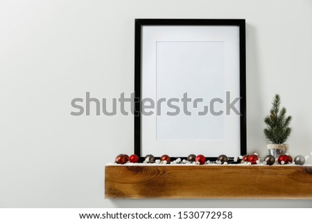 Christmas decorations in bright shiny colors with Christmas lights with blurred white wall background.