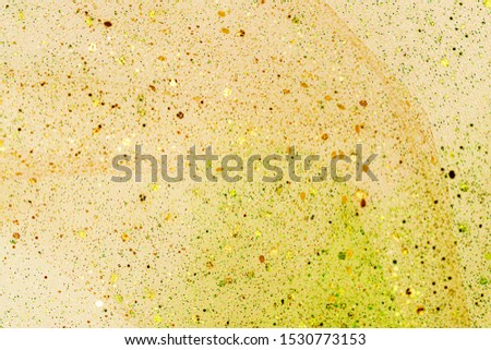 Metallic glitter gold cloth texture, close up. Christmas yellow green gradient background. Festive metallic shimmers background in warm pastel colors.  