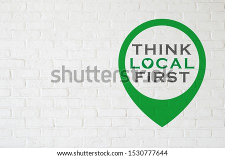 Brick wall with THINK LOCAL FIRST Royalty-Free Stock Photo #1530777644