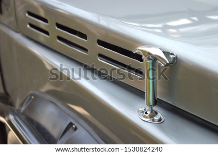 Picture of a silver hook used to hold the car bonnet