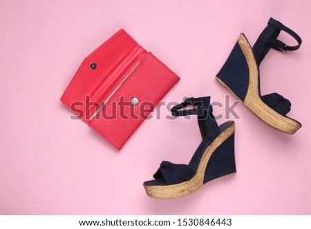 Minimalistic feshin still life. Sandals with platform, leather wallet on pink pastel background. Top view