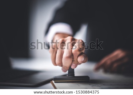Close-up Of A Person's Hand Stamping With Approved Stamp On Text Approved Document At Desk,  Contract Form Paper Royalty-Free Stock Photo #1530884375