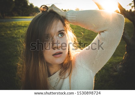 Young girl looking up taking photoshoot during sunset in Victoria  British Columbia Canada during Autumn Fall looking serious and thoughtful