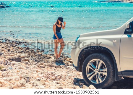 woman standing at the beach car travel concept