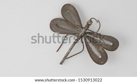 Illustration of a jewelry brooch in brass with shape of dragonfly on a white background