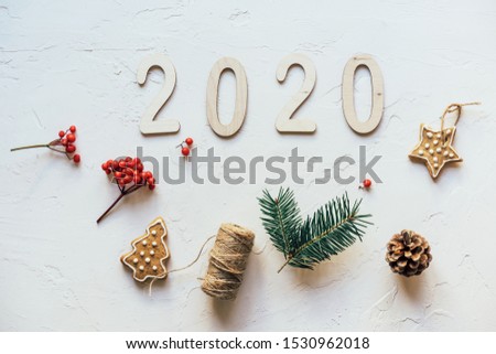 Minimalistic Christmas flat lay on a white background with simple baubles and wooden numbers 2020. Festive concept.