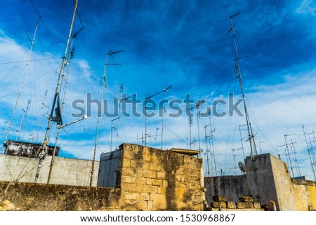 Old buildings in the city of Bari with roofs full of old television antennas.