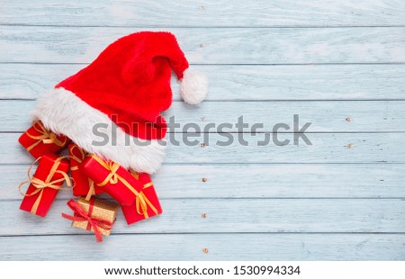 Gift boxes with santa hat on wooden background