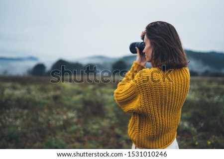 photographer traveler take photo on video camera closeup on background autumn foggy mountain, tourist shooting nature mist landscape outdoor, hobby concept copy space mockup