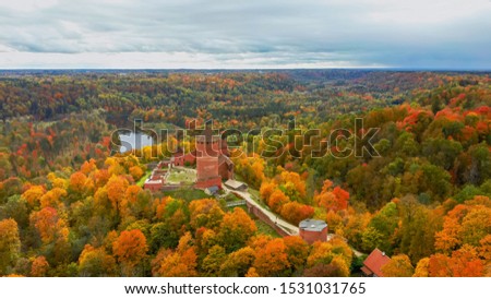Autumn Landscape View of the Old Turaida Castle , Build From Red Bricks. Surrounded by Forests Colorful Bright Yellow Orange and Green Trees, Sunny Day. During Golden Autumn Season in Latvia, Sigulda