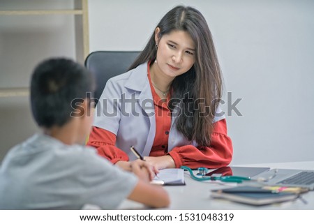 Female doctor talking to boy patient