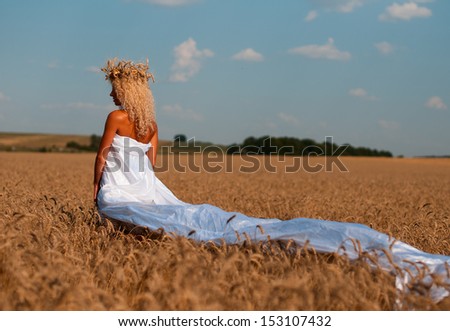 Adorable little girl playing in the wheat field on a warm summer day