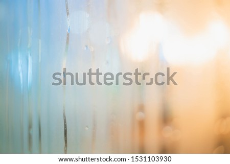 Drops of rain on window with abstract lights. Drops Of Rain On Blue Glass Background. Street Bokeh Lights Out Of Focus. 