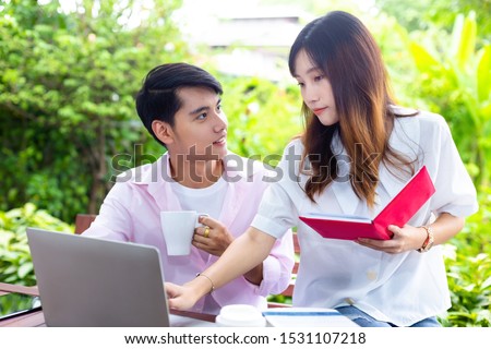 Asian young man and pretty woman working with paperwork and laptop in garden at home, The start up business couple works with happiness