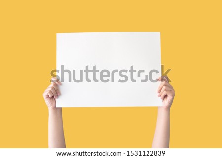 hand holding white blank paper isolated on yellow background with clipping path