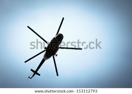 Helicopter flying against the blue sky Royalty-Free Stock Photo #153112793