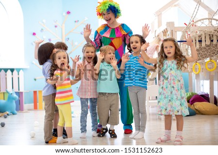 Clown and children group playing indoor . Holiday in a children's club. Games with animator