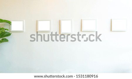 white photo frames mockup isolated on white plastered wall .