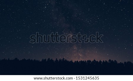 Milky way in the forest landscape affect the viewer's imagination, dense virgin forests on the slopes contribute to conceal the traces of civilization, illuminated Tent