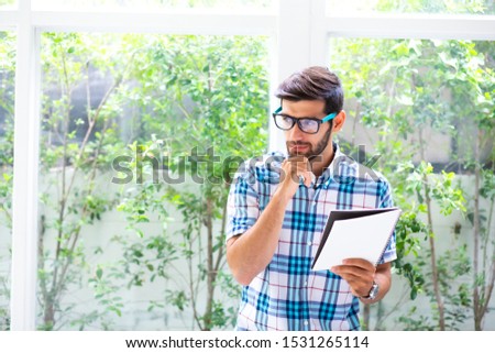 The male writer is writing a new story and writing it down in his notebook. Busineeman working at home concept