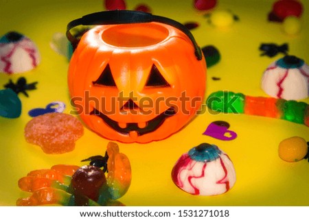 halloween candies seen close up on yellow background
