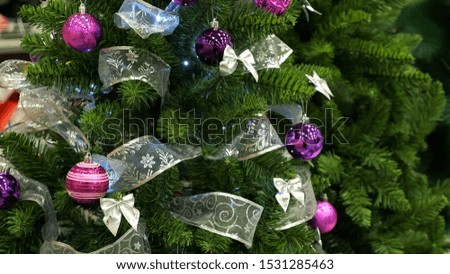 wonderful artificial christmas tree with bright sparkling decorations and shining garlands in shop extreme close view