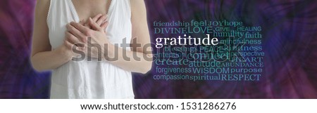 Heartfelt gratitude word tag cloud banner - female torso in white robes with hands laid on chest beside a GRATITUDE word cloud against a dark purple magenta blue and green complex pattern
