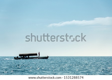 One tourist boat on calm blue water of Indian Ocean