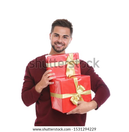 Happy young man holding Christmas gifts on white background