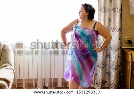 pictured in the photo young woman posing in a purple swimwear and lilac pareo