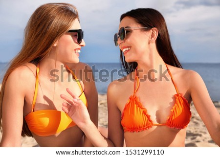 Young couple in bikini spending time together on beach