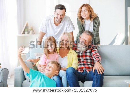 Little boy taking photo with his family at home