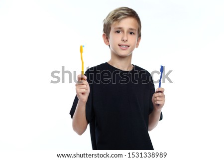 Happy little boy holding toothbrush and smiling.