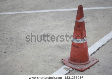 
The orange cone is located on the road.