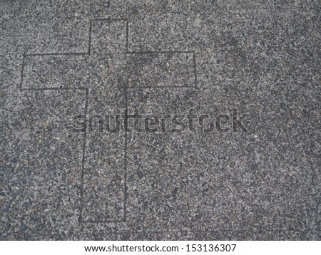 Religious cross etched in aggregate surface