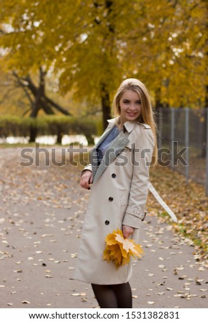 Autumn photo shoot with a beautiful blonde holding yellow leaves