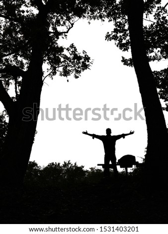 Silhouette of man spreading hand and standing on the edge of a mountain, enjoy to see the landscape above the light of the countryside area and mountain. Royalty-Free Stock Photo #1531403201