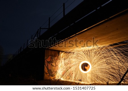 steel wool photography under a train bridge